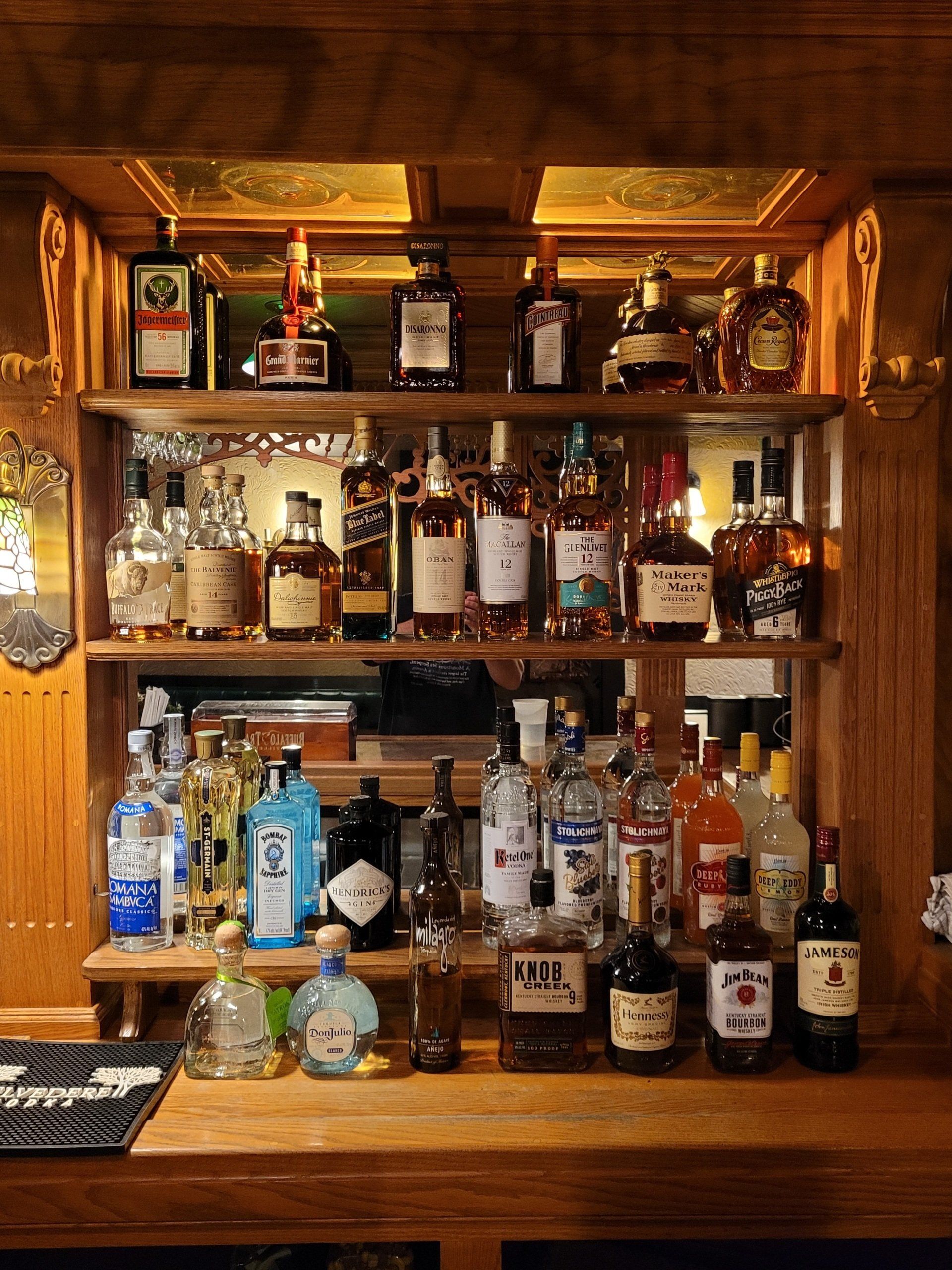 A bar filled with bottles of liquor including blue