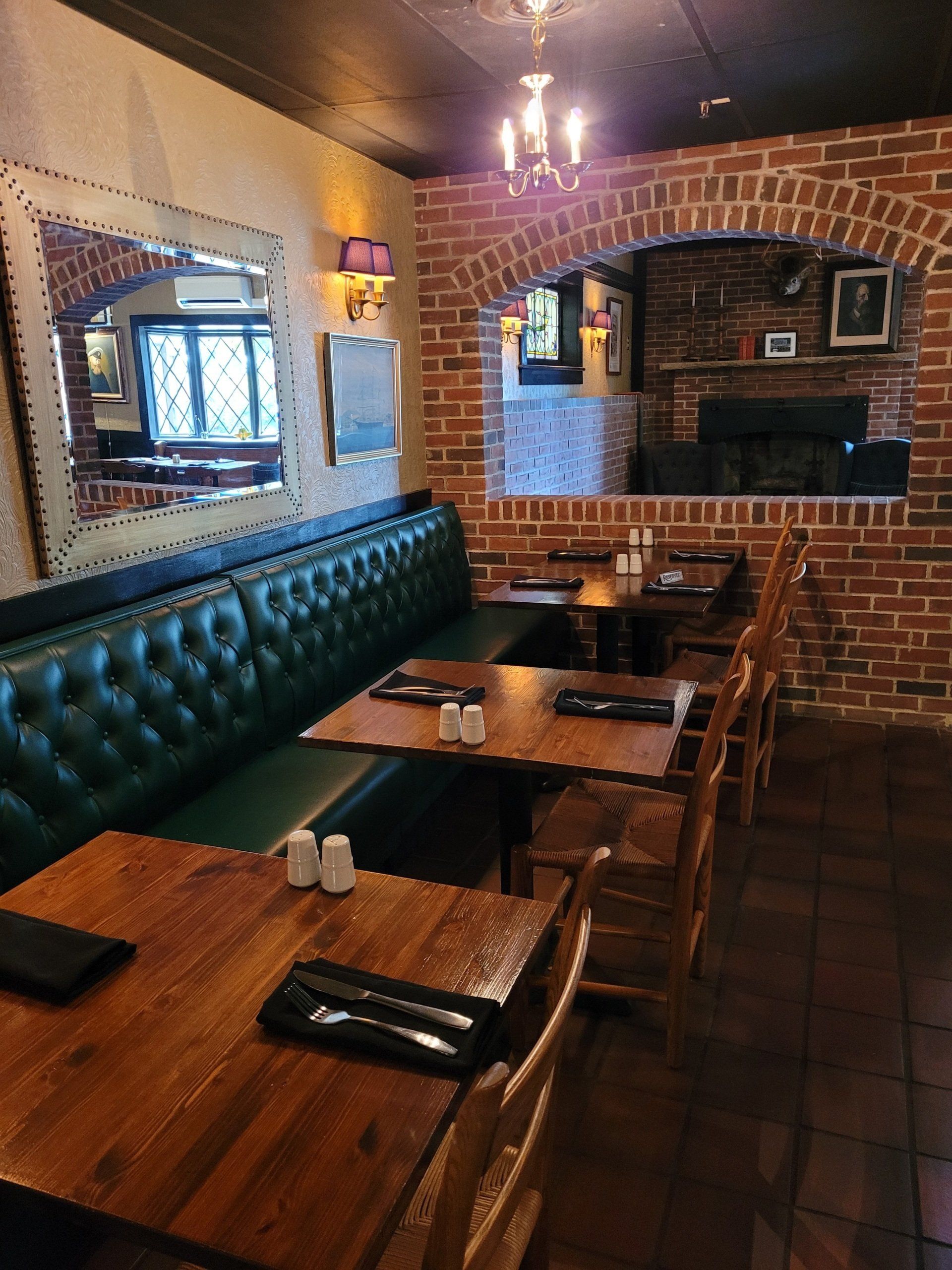 A restaurant with tables and chairs and a brick wall