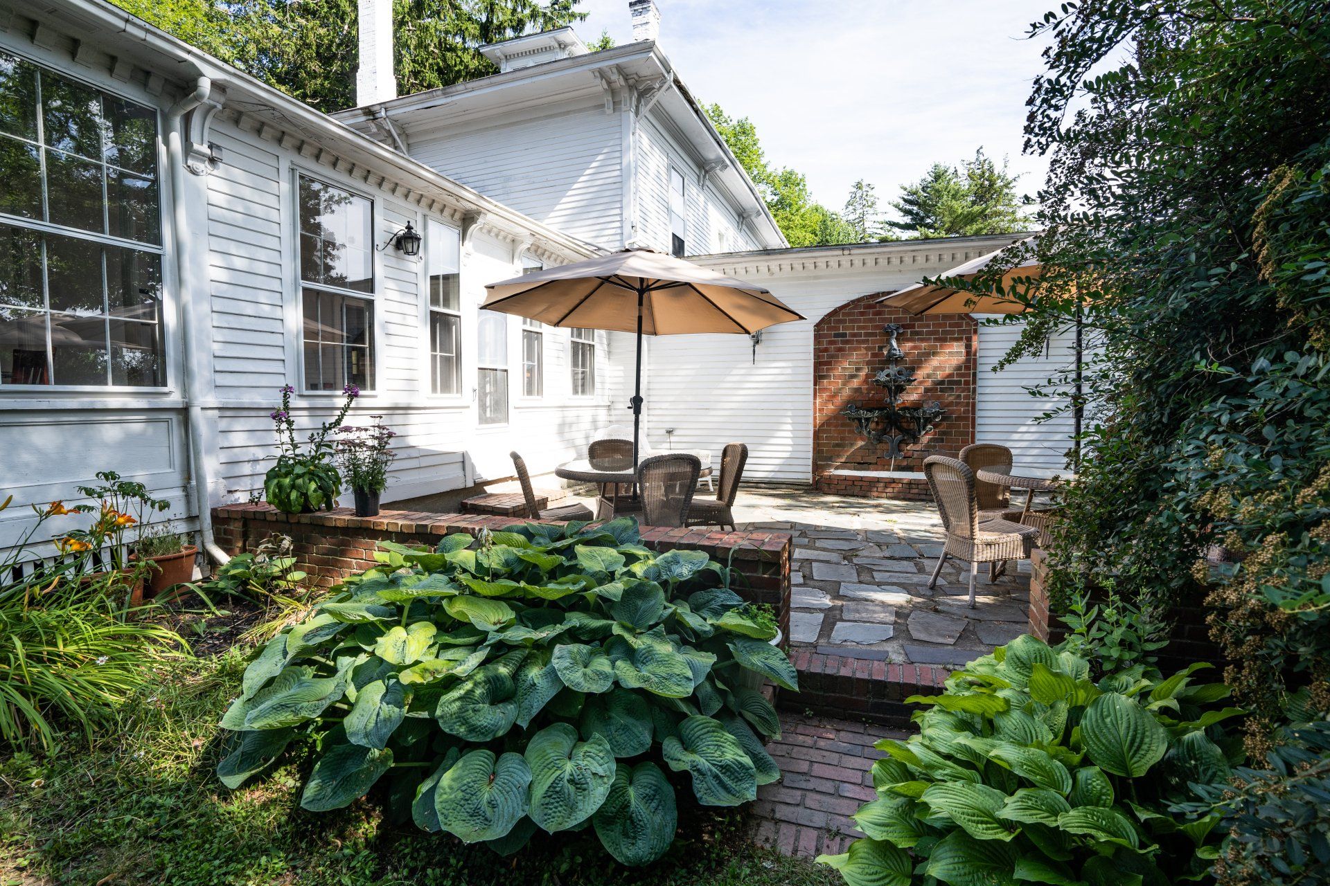 A white house with a patio and umbrellas in front of it