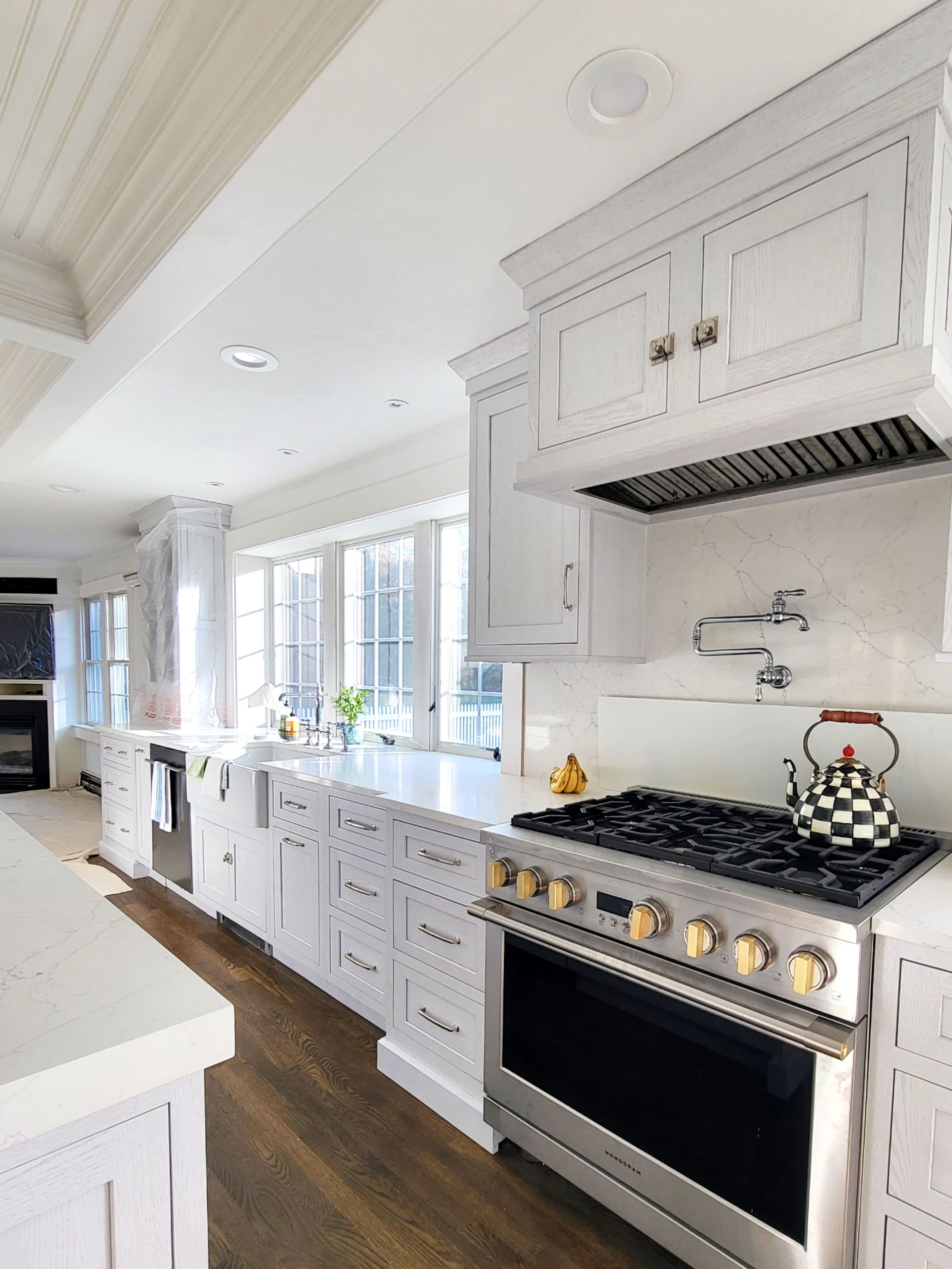 A kitchen with white cabinets and a stove top oven