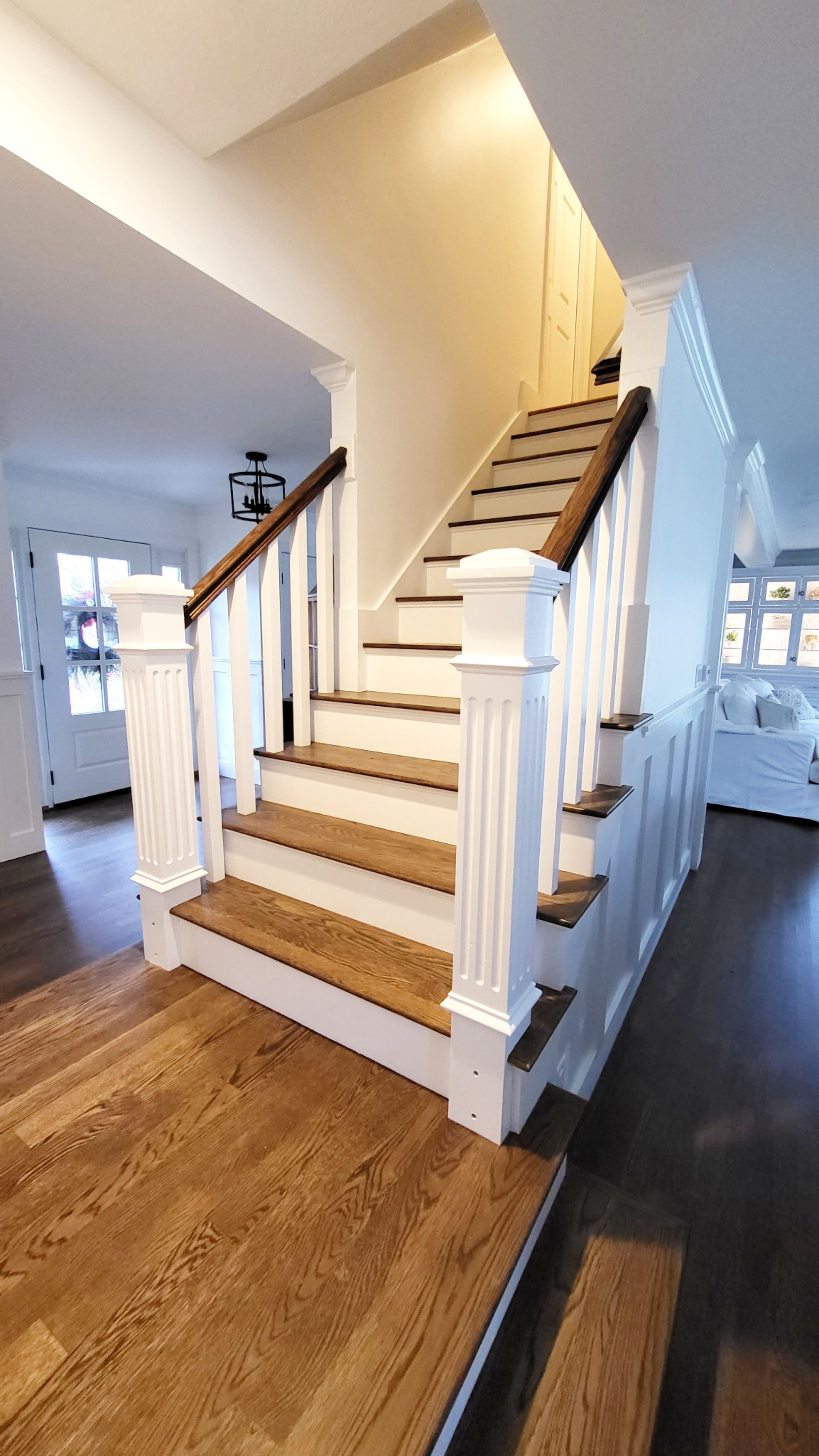 A staircase with wooden steps and a white railing in a house.