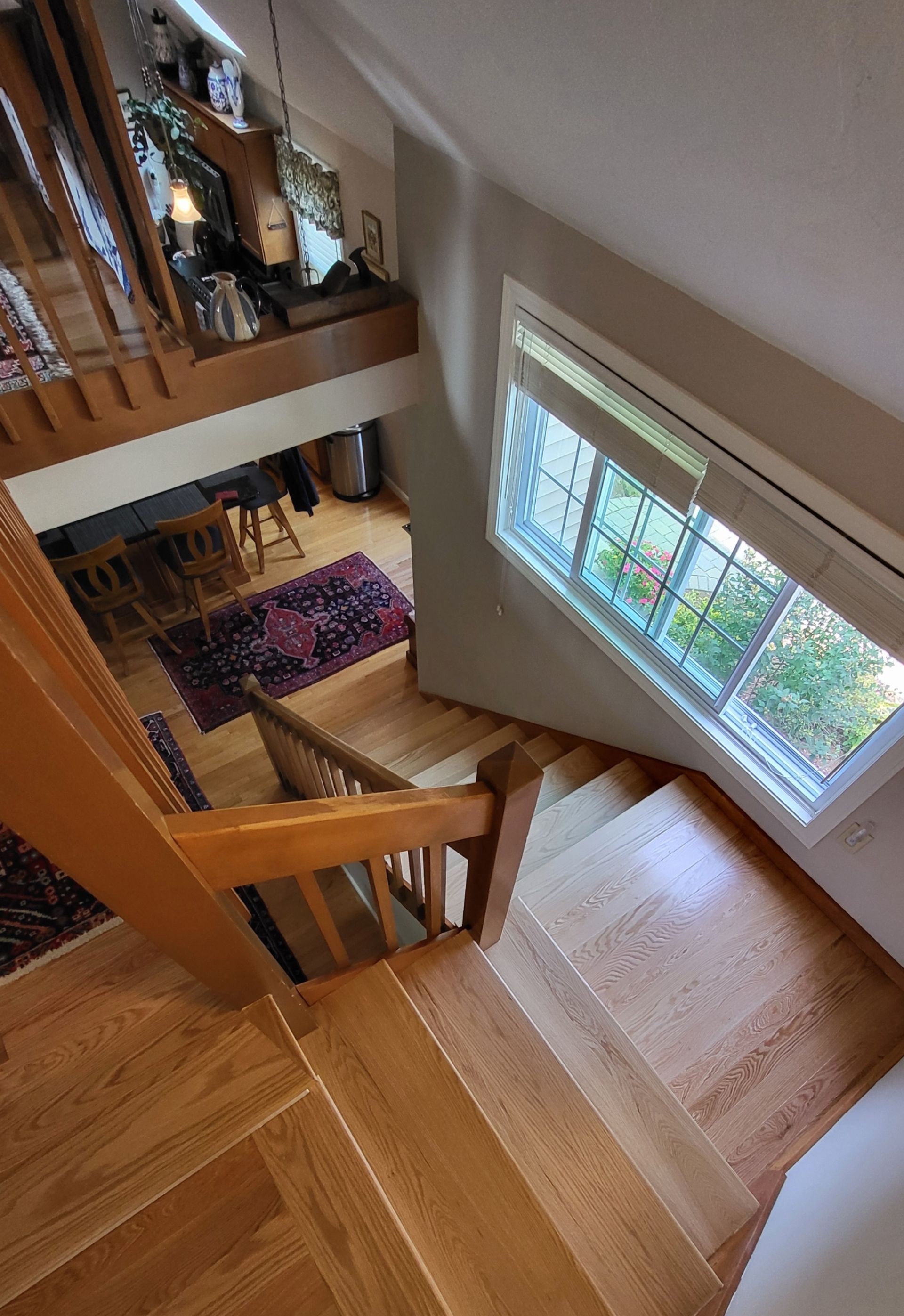 An aerial view of a wooden staircase leading to the second floor of a house.