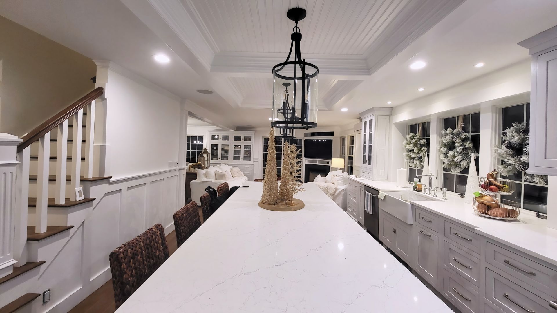 A kitchen with white cabinets and a large island in the middle.