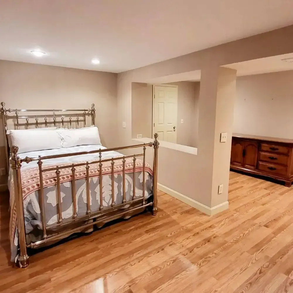 A bedroom with a king size bed and hardwood floors