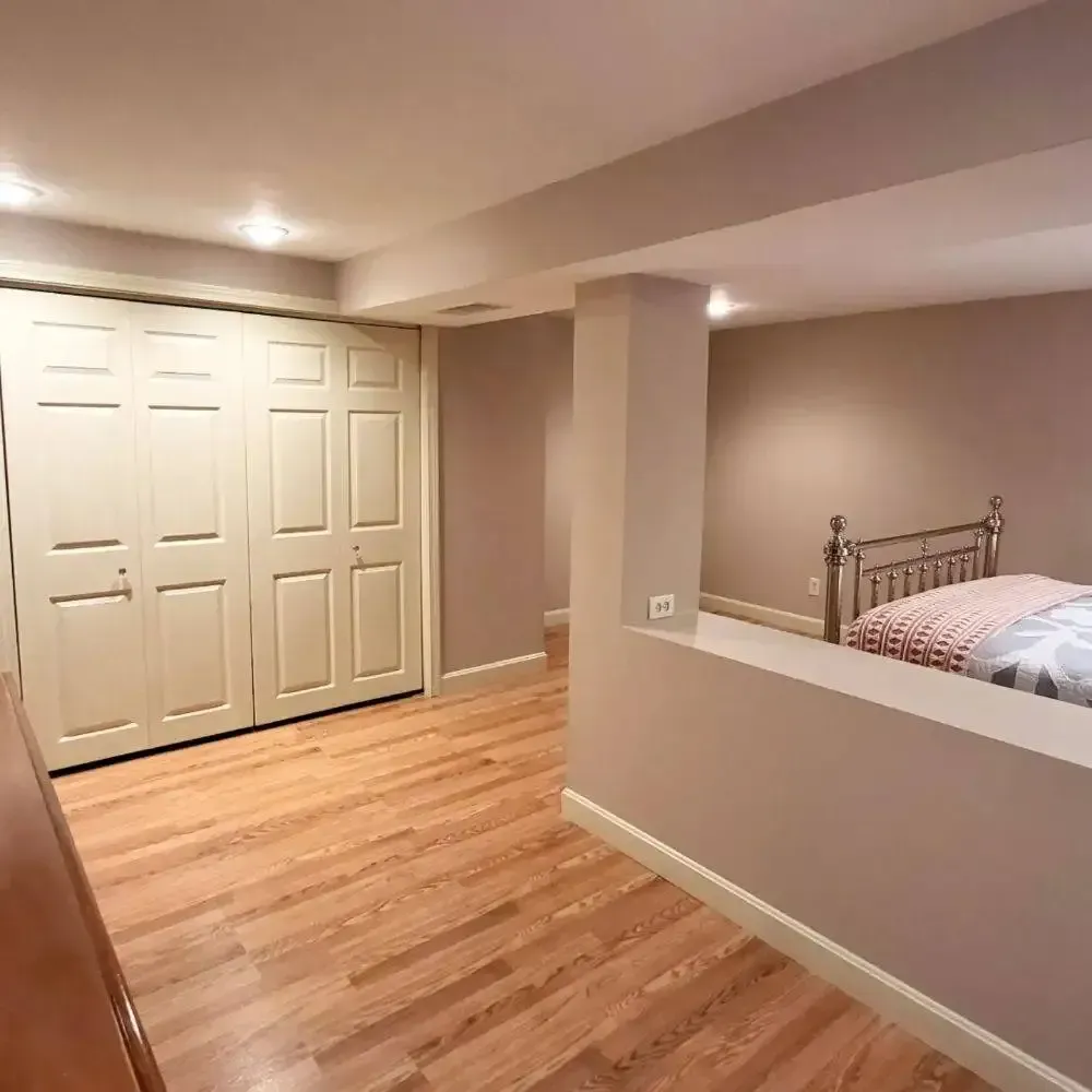 A bedroom with hardwood floors and a bed.