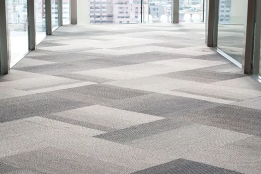 A hallway with a carpeted floor and a lot of windows.