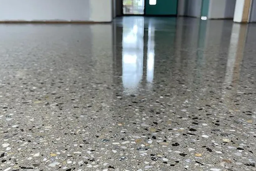 A close up of a shiny concrete floor in a hallway.