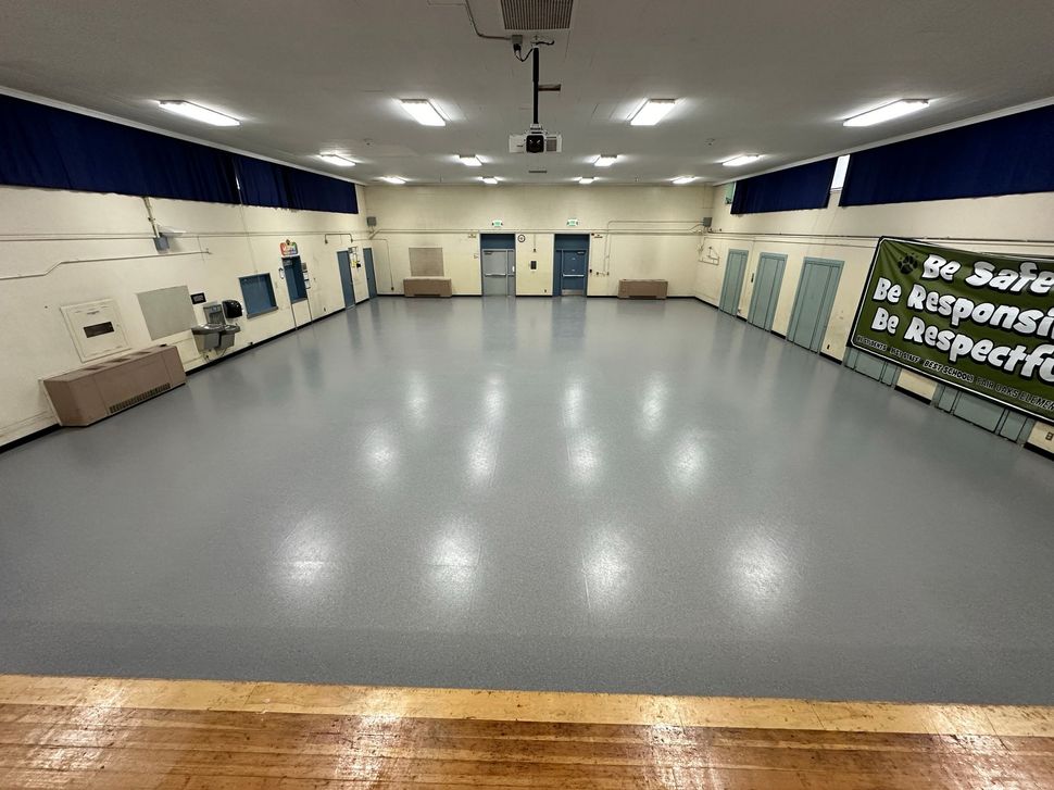 A large empty room with a projector on the ceiling.