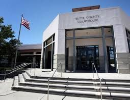 A courthouse with stairs leading up to it and a flag flying in front of it.