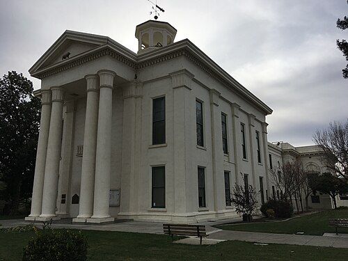 A large white building with columns and a clock tower on top of it.
