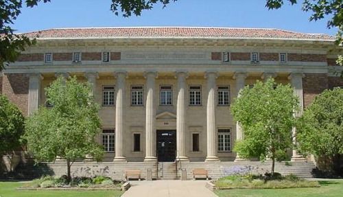 A large building with columns and trees in front of it