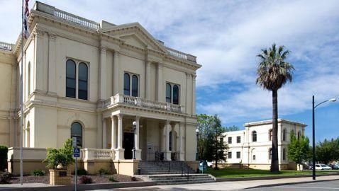 A large white building with a palm tree in front of it.