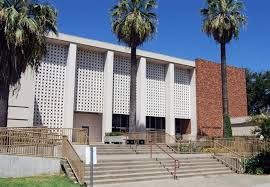 A large building with stairs and palm trees in front of it.