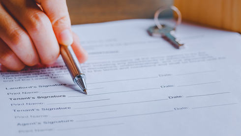 A person is writing on a piece of paper with a pen.