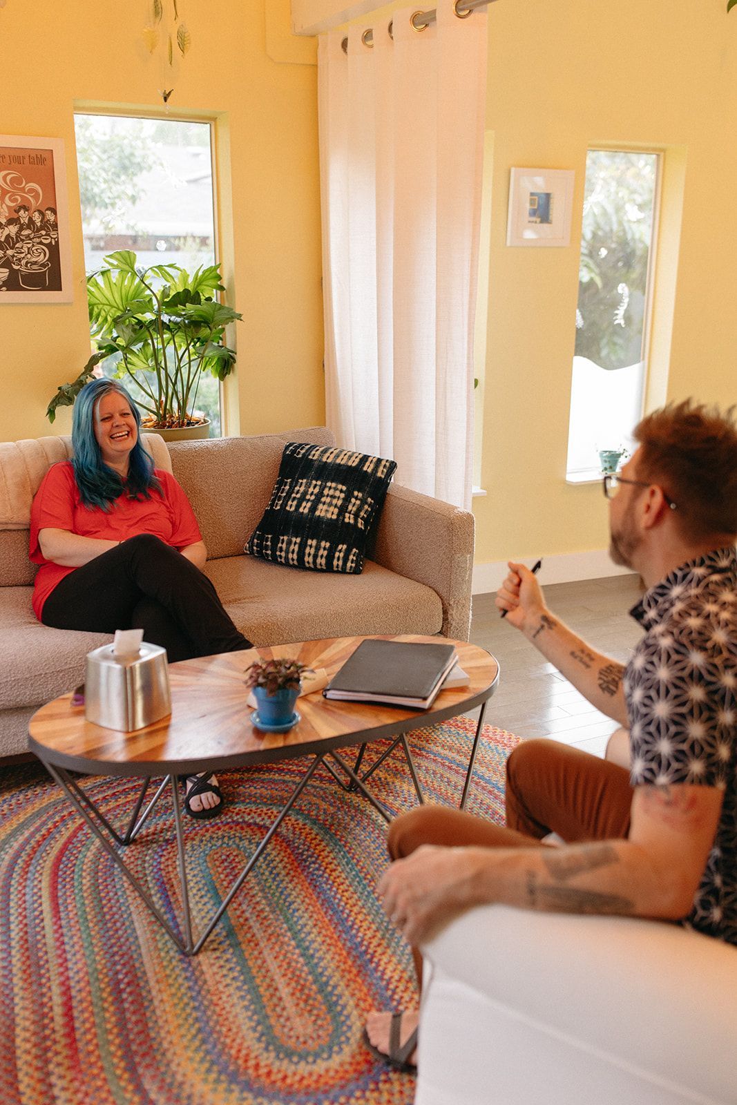 A person is sitting on a cliff overlooking a mountain range.