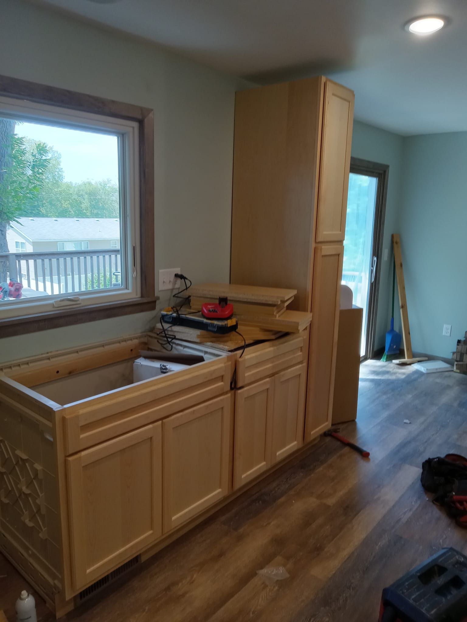 A kitchen with wooden cabinets and a sink under a window.