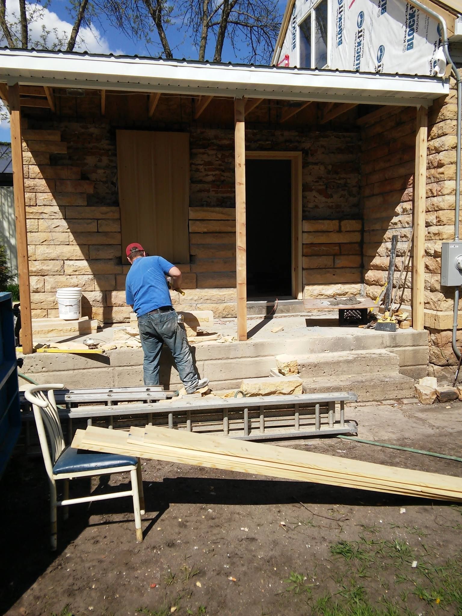 A man is working on the porch of a log cabin