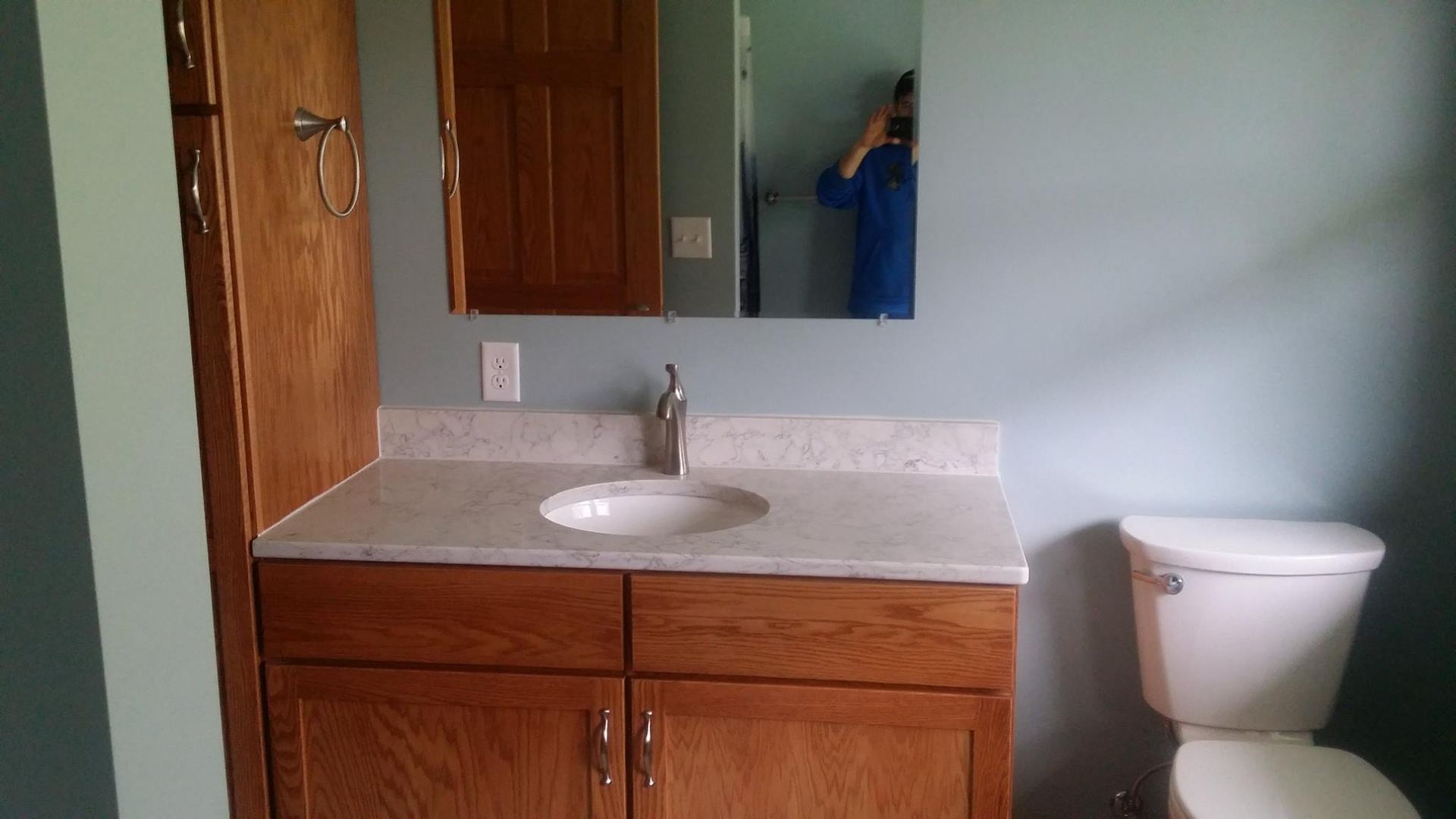 A bathroom with a sink , toilet and mirror.