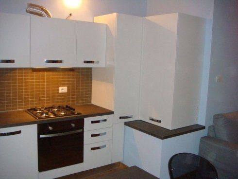 cucina angolare con scaffali bianchi