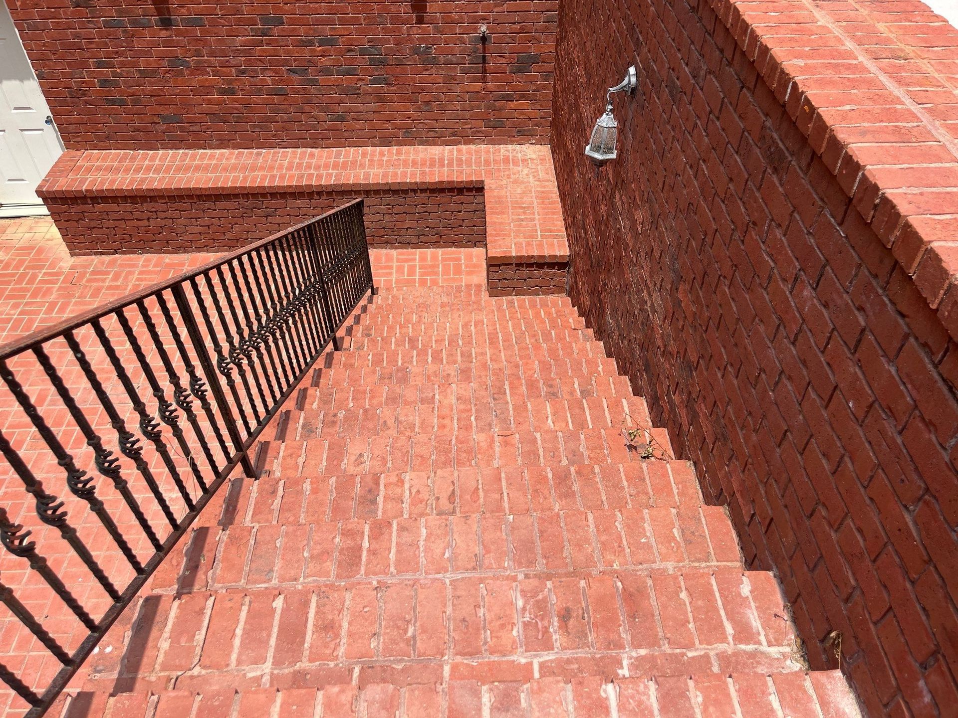 The back of a white house with a black roof and a window.