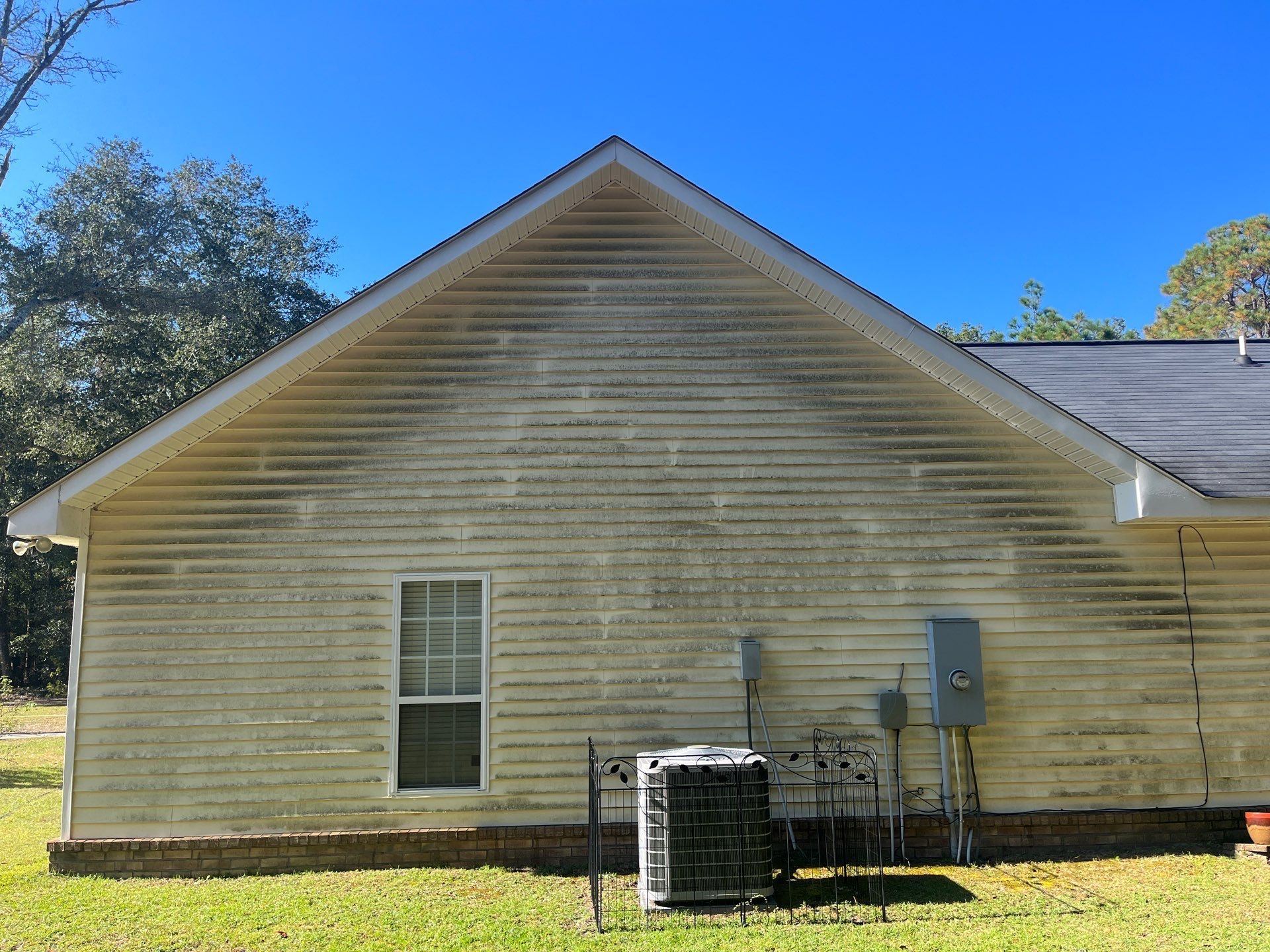 The back of a house with a window and air conditioner.