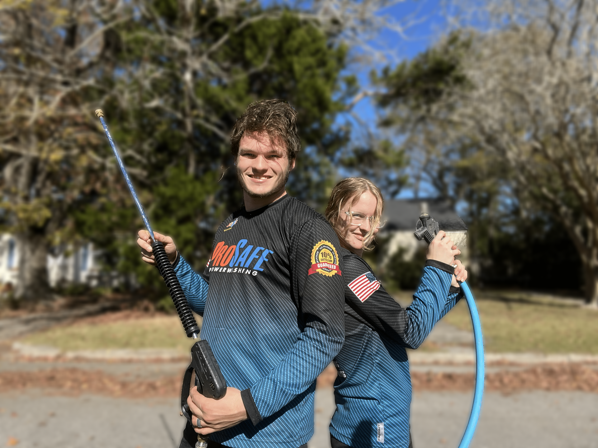 A man and a woman are standing next to each other holding a hose.