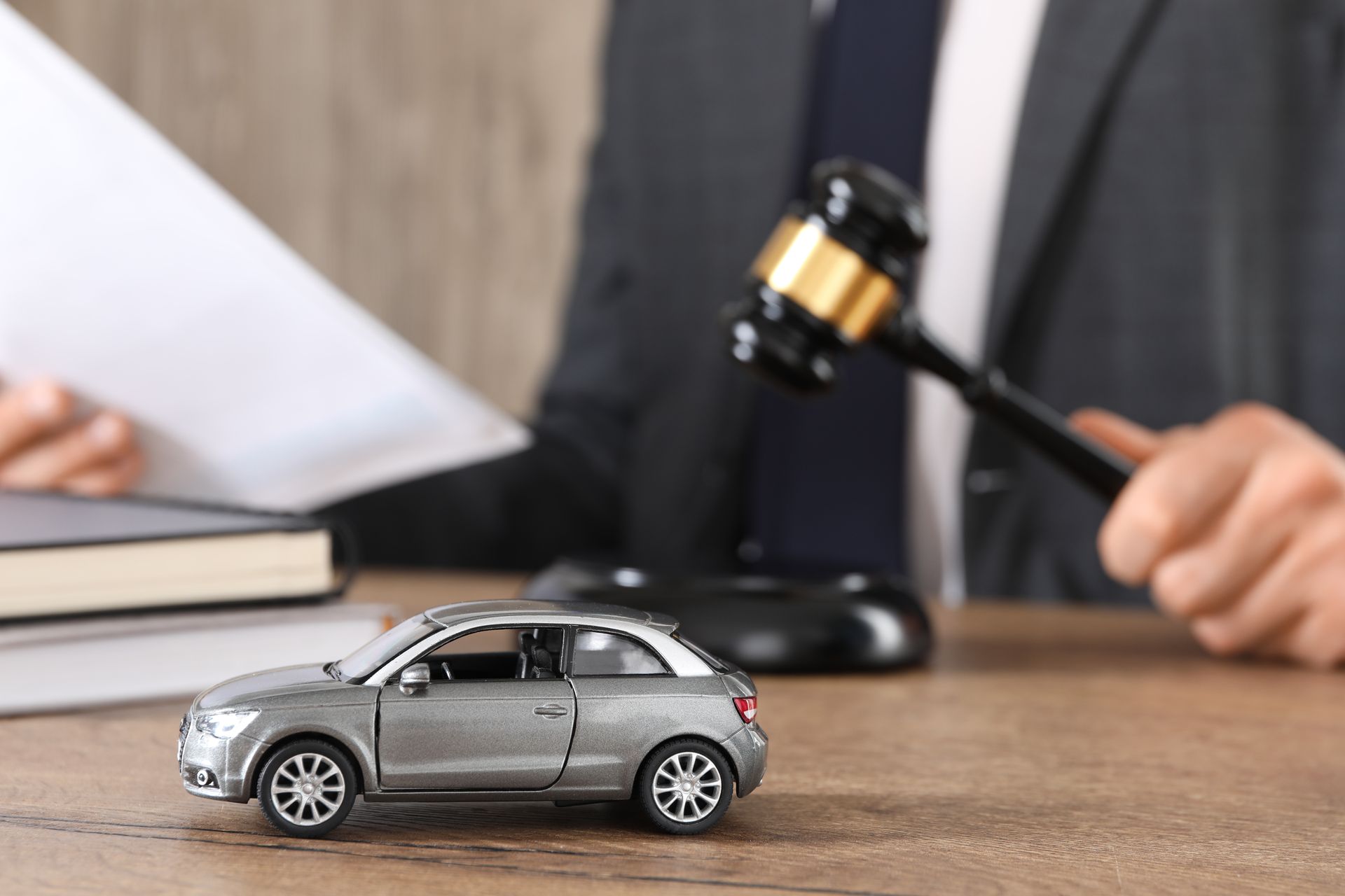 Man with document and gavel at wooden table indoors.