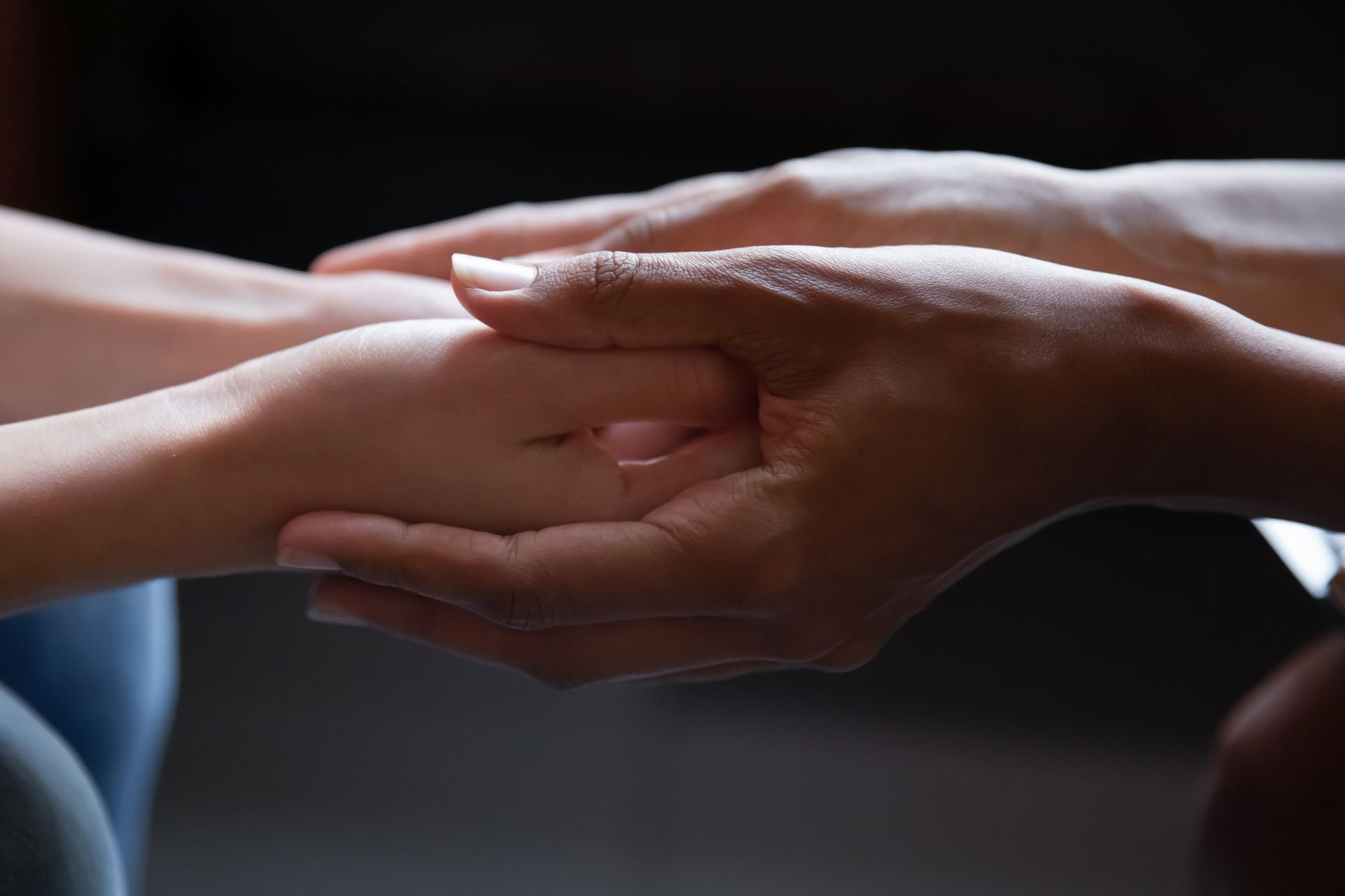 A man and a woman are holding hands over a wooden table.
