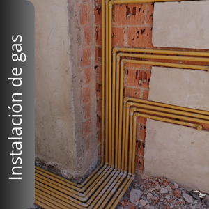 Una pared de ladrillos con un montón de tubos amarillos que la atraviesan.