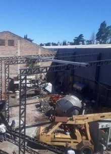 Una gran hormigonera se encuentra delante de un edificio.