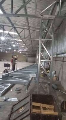 Se está construyendo una gran estructura metálica en un almacén.