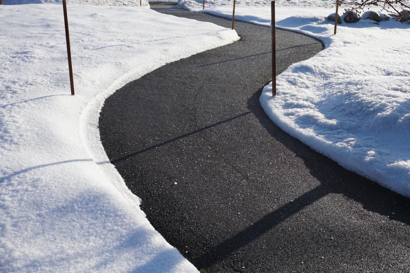 Snow-covered walkway winding through a snowy yard.