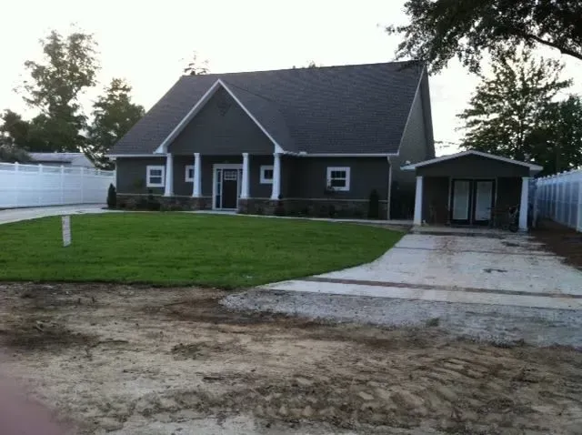 A house with a lawn and a driveway in front of it