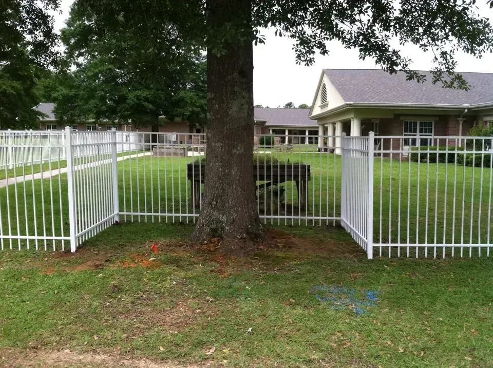 A white fence with a tree in the middle of it