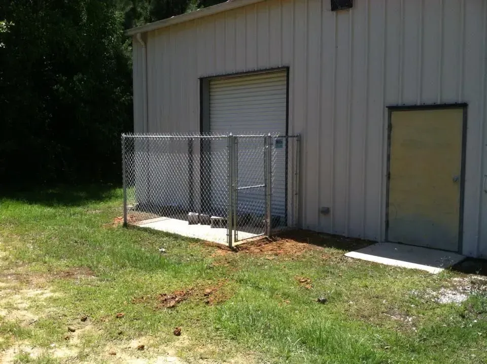 There is a chain link fence in front of a building.