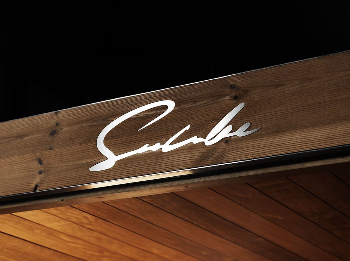 Un panneau en bois d'un sauna avec une signature blanche dessus