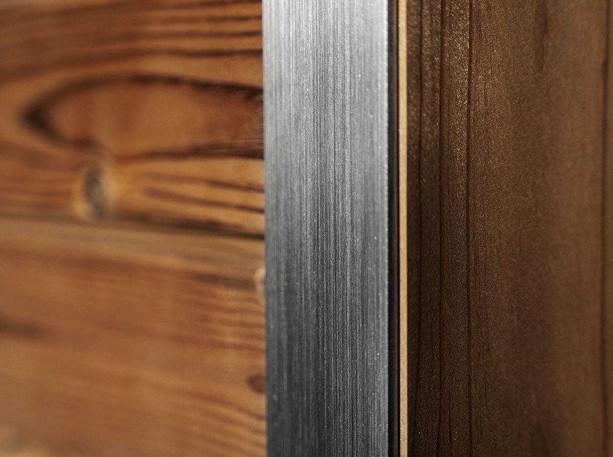 Un gros plan d'un morceau de métal à côté d'un morceau de bois d'un sauna