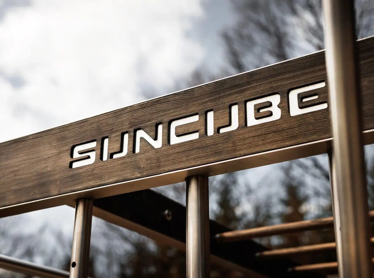 Un homme fait du sport sur une structure métallique Gymcube.