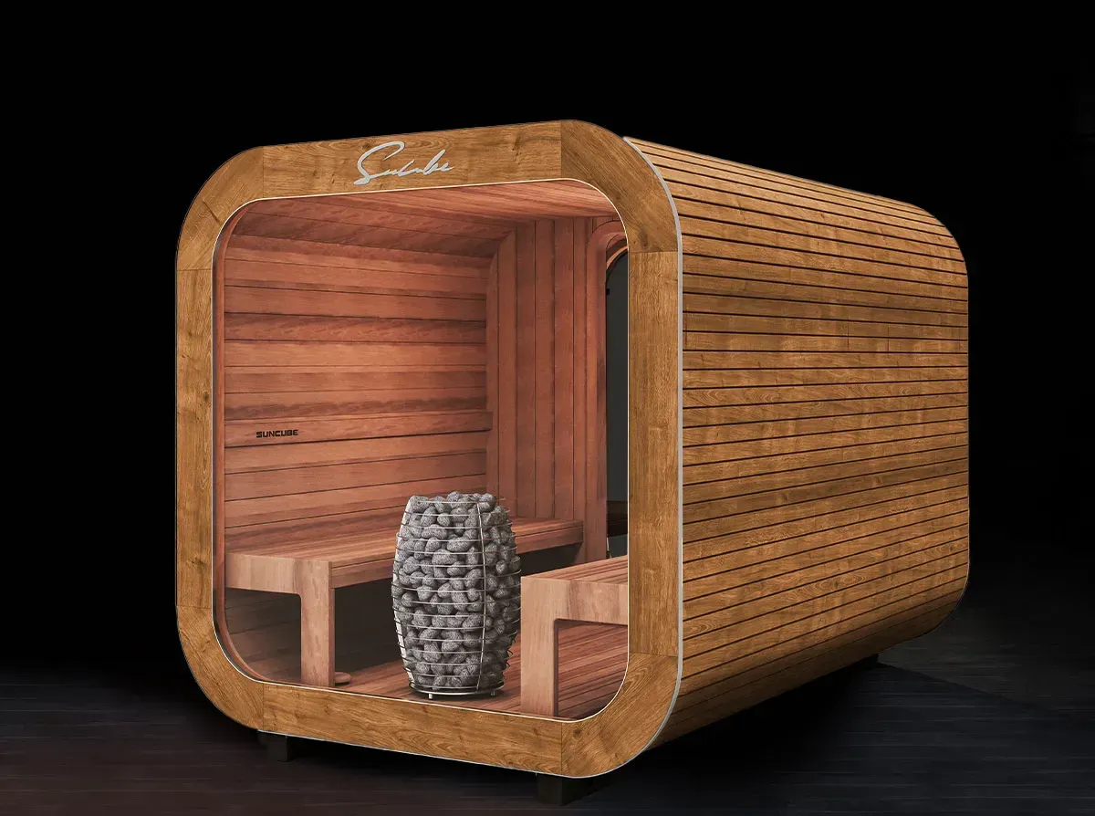 Un sauna en bois avec une porte vitrée est posé sur un plancher en bois.