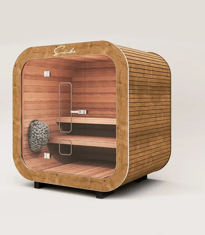 Un sauna en bois avec une porte vitrée est posé sur une surface blanche.