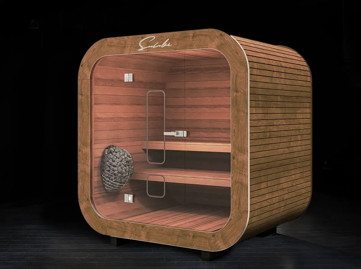 Un sauna en bois avec une porte vitrée est posé sur un plancher en bois.