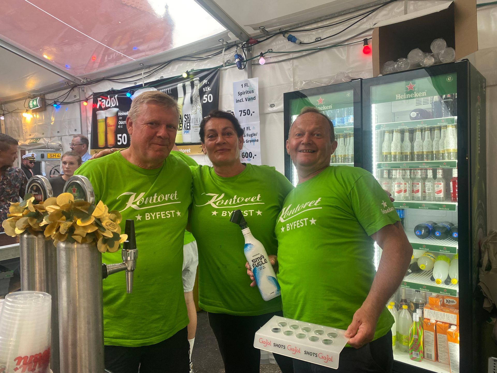 En gruppe mennesker iført grønne skjorter poserer til et billede.