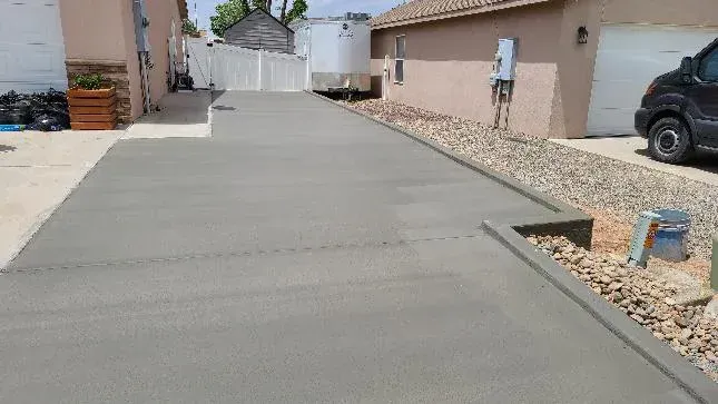 A concrete driveway is being built in front of a house.