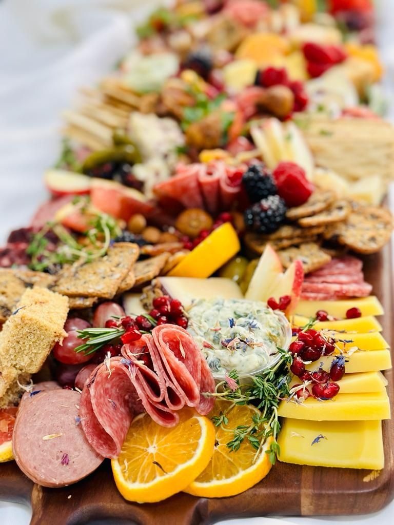 Three women are sitting at a table toasting with wine glasses.