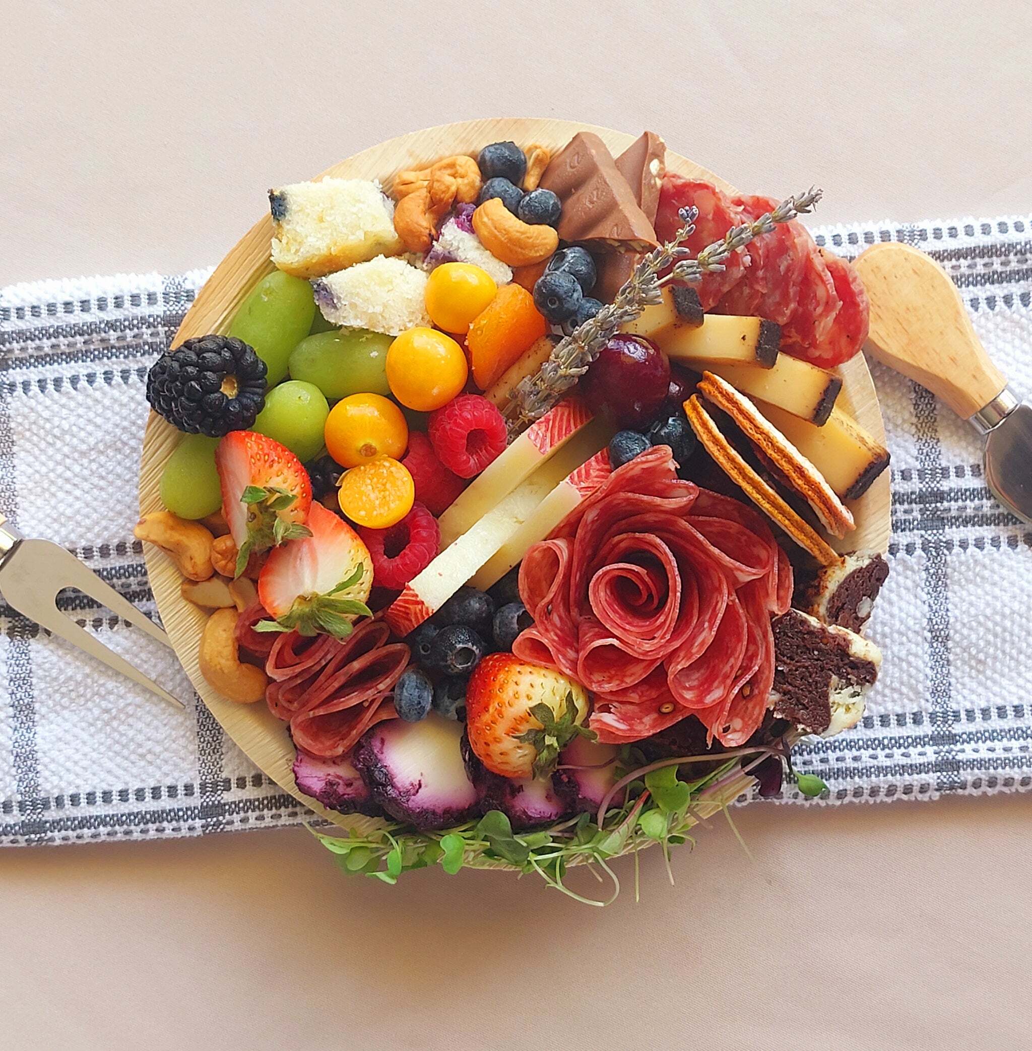 A wooden cutting board filled with a variety of fruits and meats