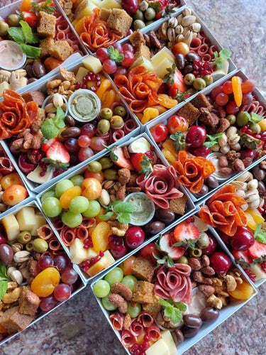 A variety of fruits and vegetables are in boxes on a table.