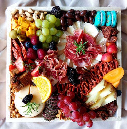 A wooden box filled with lots of different types of food.