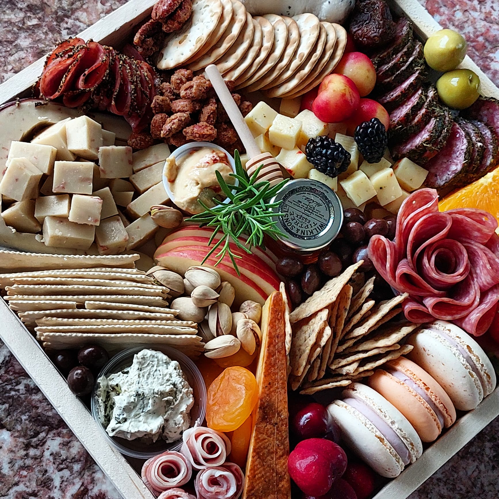A wooden tray filled with lots of different types of food.