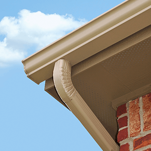 A gutter on a brick building with a blue sky in the background