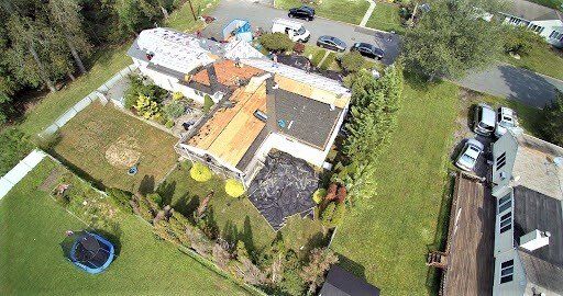An aerial view of a house with a trampoline in the backyard.